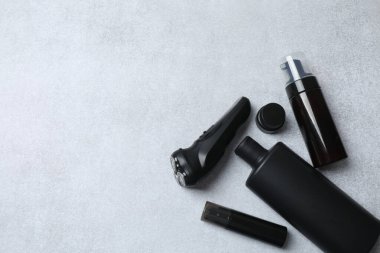 Gri masadaki farklı makyaj ürünleriyle düz konum