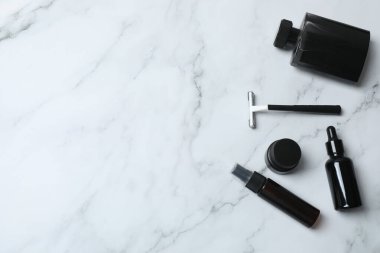 Beyaz arka planda kozmetik şişeler ve makyaj fırçaları.