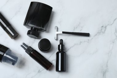Beyaz mermer masaya farklı kozmetik ürünlerle dizilmiş, düz yatıyordu.