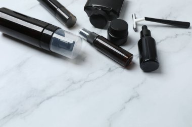 Kozmetik ürünleri ve aksesuarlar mermer bir masada.