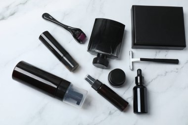 Beyaz arkaplanda siyah makyaj ürünleri.