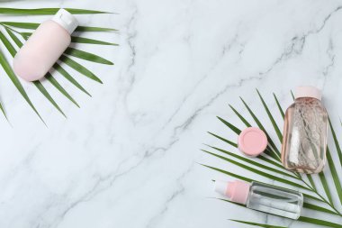 Açık mermer zemin üzerinde kozmetik ürünleri bulunan düz bir kompozisyon. Metin için boşluk