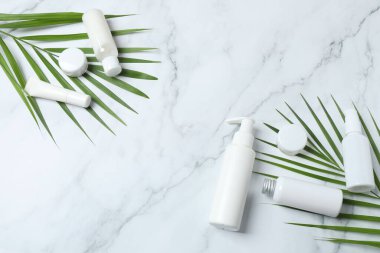 Gri arkaplanda kozmetik ürünlerle düz kompozisyon