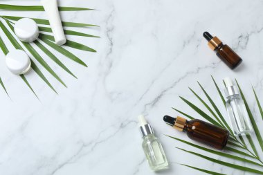 Beyaz mermer zemin üzerinde farklı kozmetik yağlar ve temel yağlar