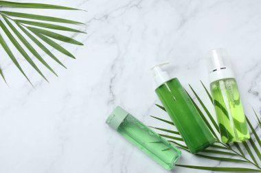 Mermer zemin üzerinde beyaz bir yaprak ile yeşil kozmetik