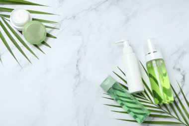 Açık arkaplanda kremalı kozmetik şişeleri ve aloe vera