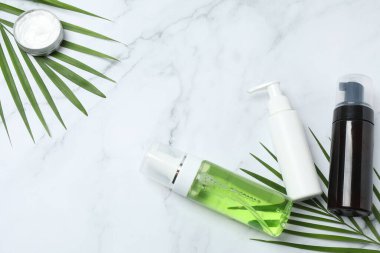 Beyaz mermer zemin üzerinde kozmetik ürünleri ve bir şişe gerekli yağ düz yerde. Metin için boşluk