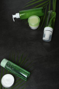 Kozmetik şişeleri ve yeşil yaprak