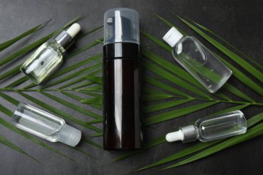 Gerekli yağ şişeleri ve gri arka planda taze yapraklar, düz yatıyordu.