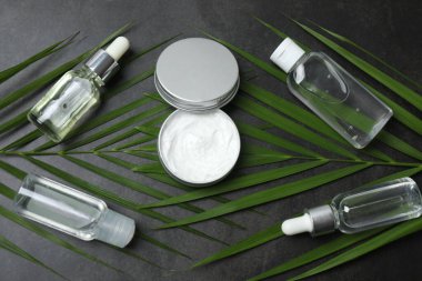 Gri arka planda doğal kremi olan kozmetik şişeleri.