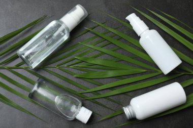 Beyaz arka planda doğal kozmetik şişeleri, yapraklar ve palmiye yağı