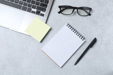 Masada dizüstü bilgisayarı, gözlüğü ve kalemi olan düz bir kompozisyon. Metin için boşluk