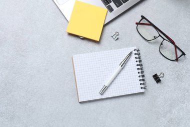 Açık gri arka planda ofis malzemelerinin olduğu düz bir kompozisyon. Metin için boşluk