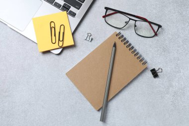 Not defteri ve malzemelerle dolu ofis masası.