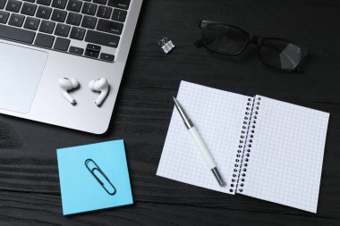 Not defteri ve dizüstü bilgisayarı olan bir ofis çalışma masası. Kopyalama alanı olan üst görünüm.