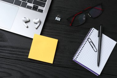 Not defteri, gözlük, kalem ve akıllı telefonu olan bir iş yeri. Yukarıdan görünüm.