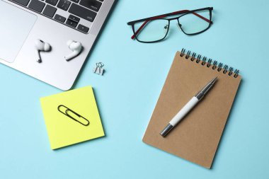 Bilgisayarlı, not defterli, gözlüklü, not defterli ve kalemli iş yeri.