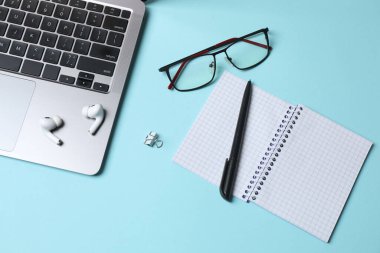 Gri arkaplan üzerine metin için ofis malzemeleri, dizüstü bilgisayar ve boşluk içeren düz konum