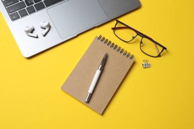 Dizüstü bilgisayarı ve not defteriyle ofis masasının üst görüntüsü