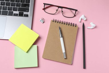 Düz konum dizüstü bilgisayar, kırtasiye malzemesi, gözlük ve kırtasiye malzemesi renkli arka planda. Metin için boşluk