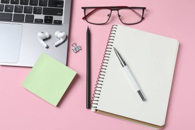 Pembe arka planda ofis malzemeleri. en üstteki görünüm