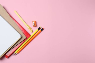 Okul malzemelerinin pembe arka plandaki üst görüntüsü