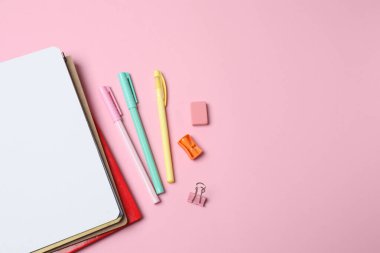 Kalemleri, pembe kalemleri ve kopyalama alanı olan defterin üst görüntüsü. okul konseptine geri dön.