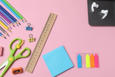 Pembe arkaplandaki okul malzemelerinin fotokopi alanı ile üst görünümü
