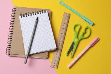 Okul kırtasiyesi ve pembe arka planda not defteri. düz yat