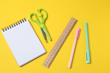 Okul malzemeleri sarı kağıtta. en üstteki görünüm.