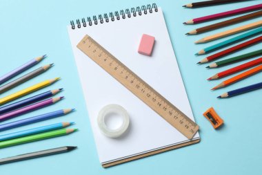 Okul malzemeleri ve beyaz ahşap zemin üzerine boş kağıt