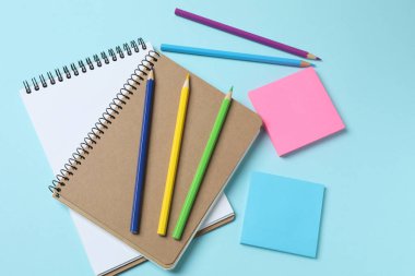 Pembe kağıt üzerinde renkli defter ve kırtasiye malzemesi