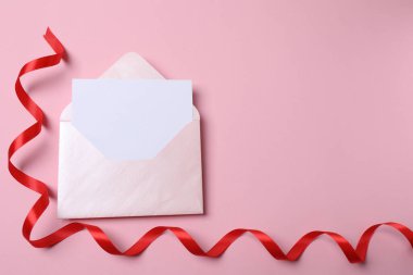 Zarf ve pembe arka planda boş kart. Üst Manzara. Metnin için boşluk