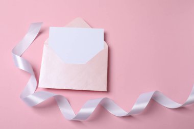 Boş zarf, kart ve pembe arkaplan üzerine boş beyaz kağıt
