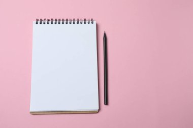 Pembe arka planda beyaz bir kağıt olan defter. metin için yer