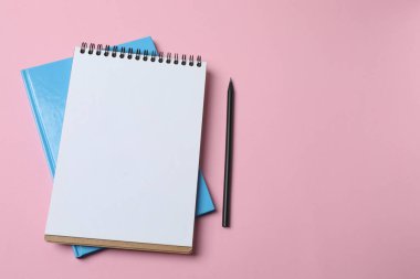 Not defterini aç, boş kağıt ve kalemler, renk arkaplanı, üst görünüm