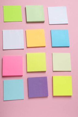 Pembe arkaplandaki boş yapışkan notlar