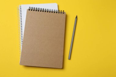 Sarı zemin üzerinde kalem olan boş bir defter