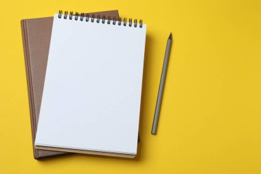 defter ve kalem sarı bir arka plan üzerinde