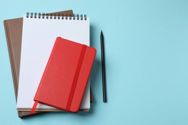 Renkli bir arkaplanda boş bir defter ve kırmızı kalem.
