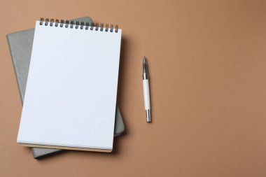 Beyaz arka planda defter, kağıt ve kalem. en üstteki görünüm