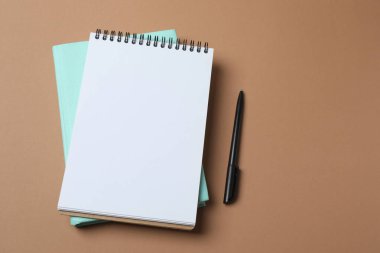 Mavi arkaplanda not defteri ve kalem aç.