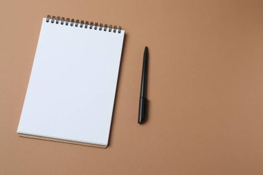 Pastel pembe arkaplanlı boş bir not defteri..