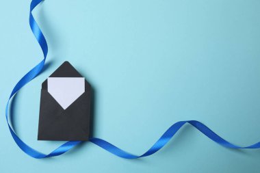 Kağıt hediye kutusu ve mavi arka planda bir fiyonk.