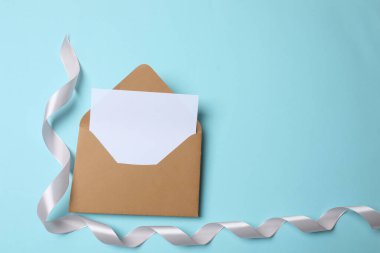 Zarf ve mektupta mavi arka planda boş bir kart var. Üst Manzara. kopyalama alanı. düz yat