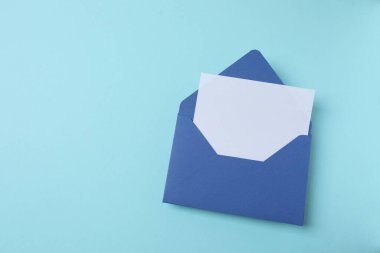 Zarf ve mavi arka planda boş kağıt. maket yap.