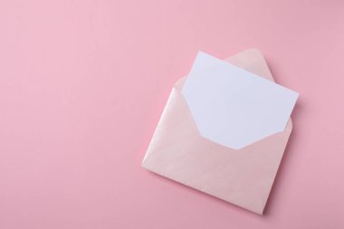 Zarf ve beyaz kart pembe arka planda, üst manzara, düz yatış. Davetiye kartı, tebrik kartı, düğün davetiyesi tasarımı