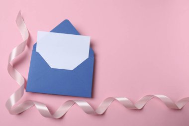 Zarfın içinde mavi arkaplan ve boş kağıt var. Düz konum, üst görünüm, kopyalama alanı. Mesajına mektup.