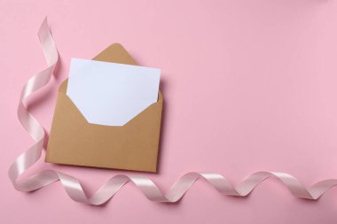 Boş beyaz bir kağıt ve pembe bir arkaplan içeren zarf.