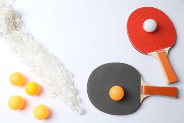 Masa tenisi raketi, toplar ve turuncu manzaralı.